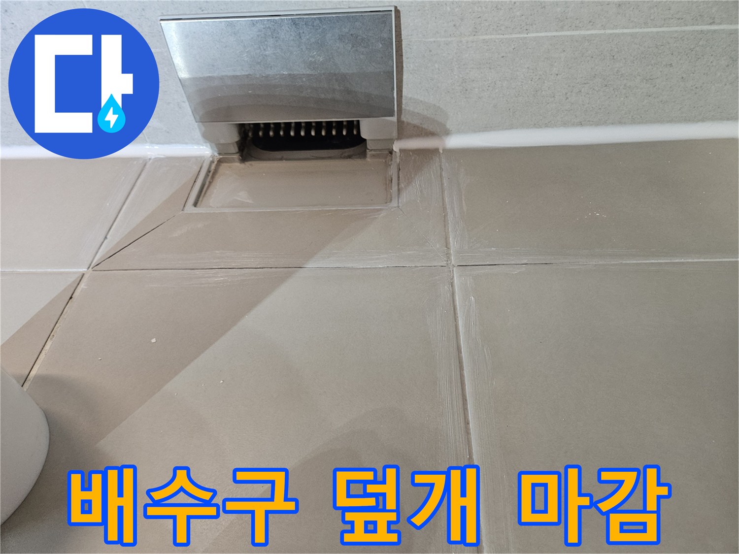 바닥 타일과 금속 배수구 덮개의 접합 부위 사진