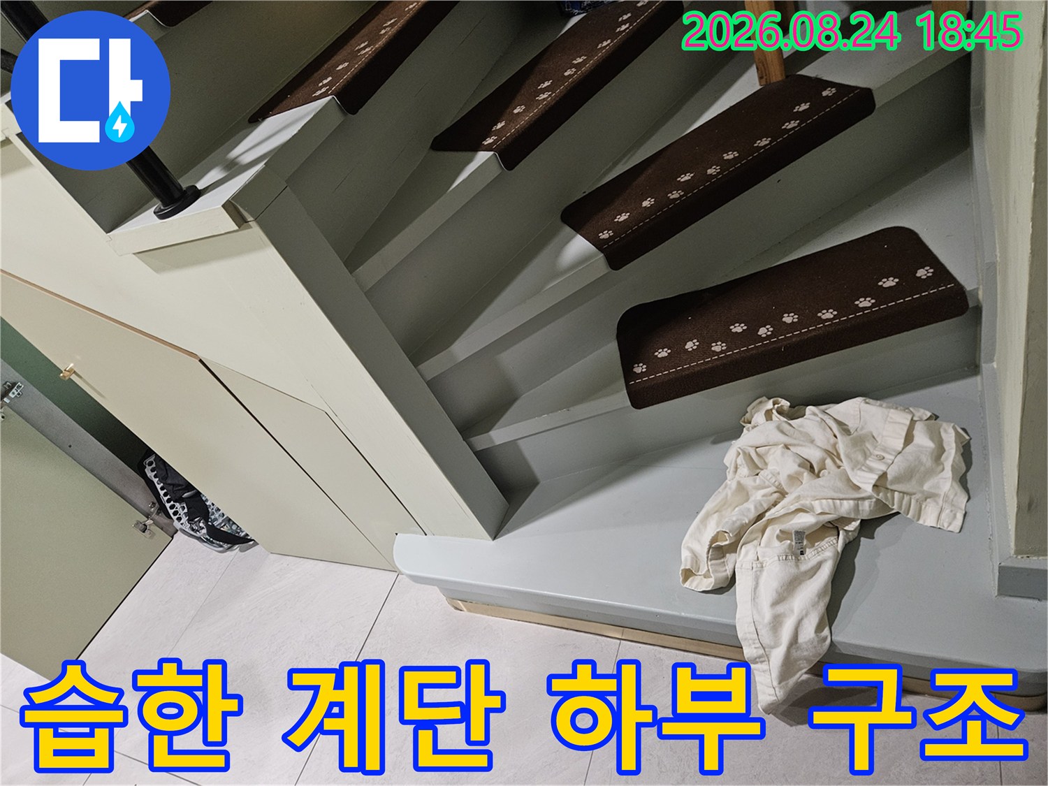 계단 아래쪽 마감 부위에 나타난 누수 징후와 습기를 촬영했습니다.