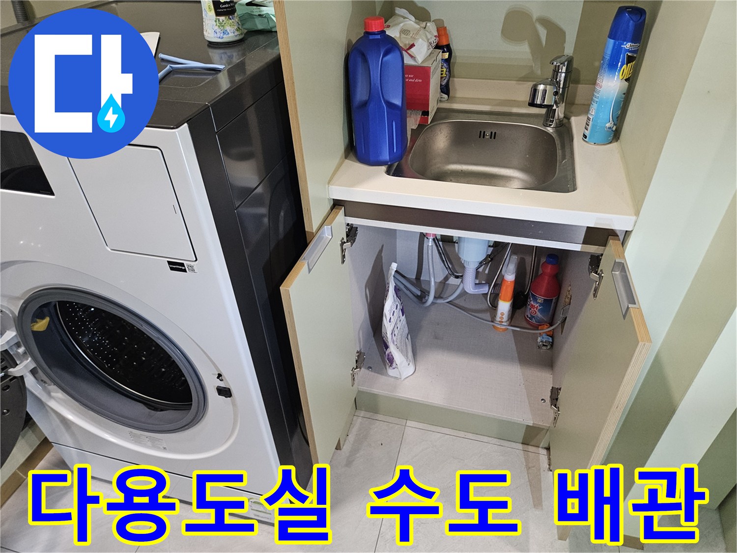 세탁기 옆 수납장 내부의 배관 및 세제류 사진