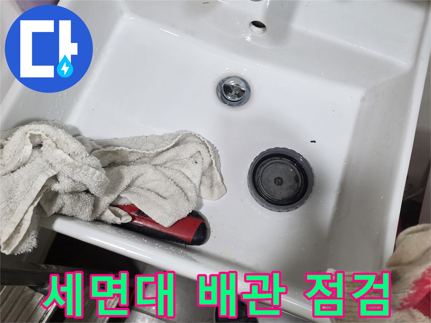 세면대 하수구 주변의 배관 상태와 팝업 부위를 근접 촬영한 모습