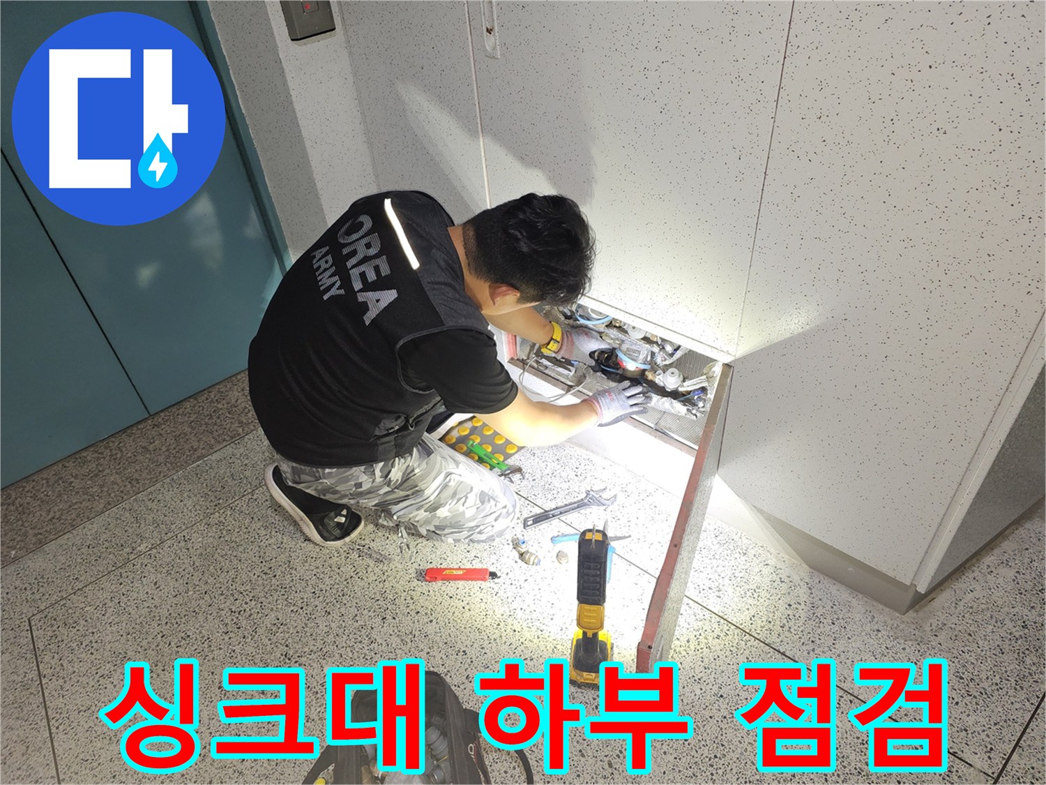 싱크대 아래 배관 구조를 꼼꼼히 살피고 있는 작업자