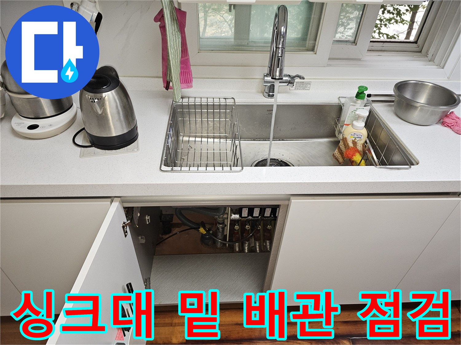 싱크대 하부 수납 공간 내부의 수도 배관 및 밸브 상세 모습
