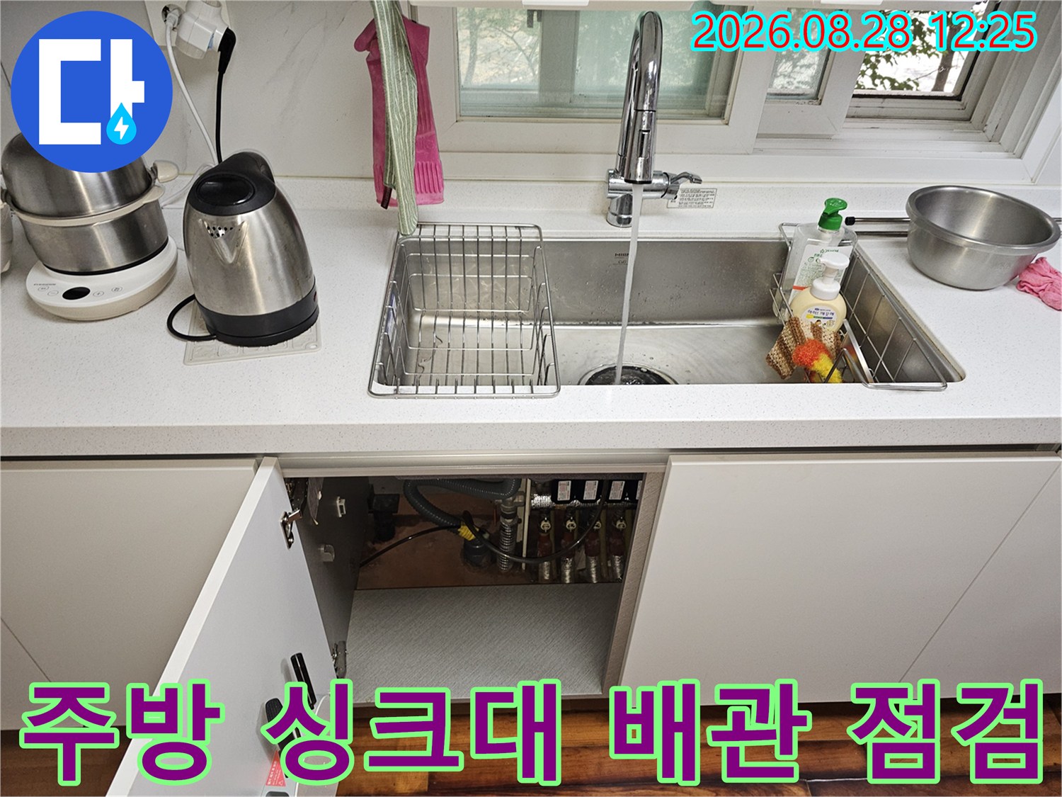 싱크대 하부장의 노출된 수도 배관과 밸브 연결 부위