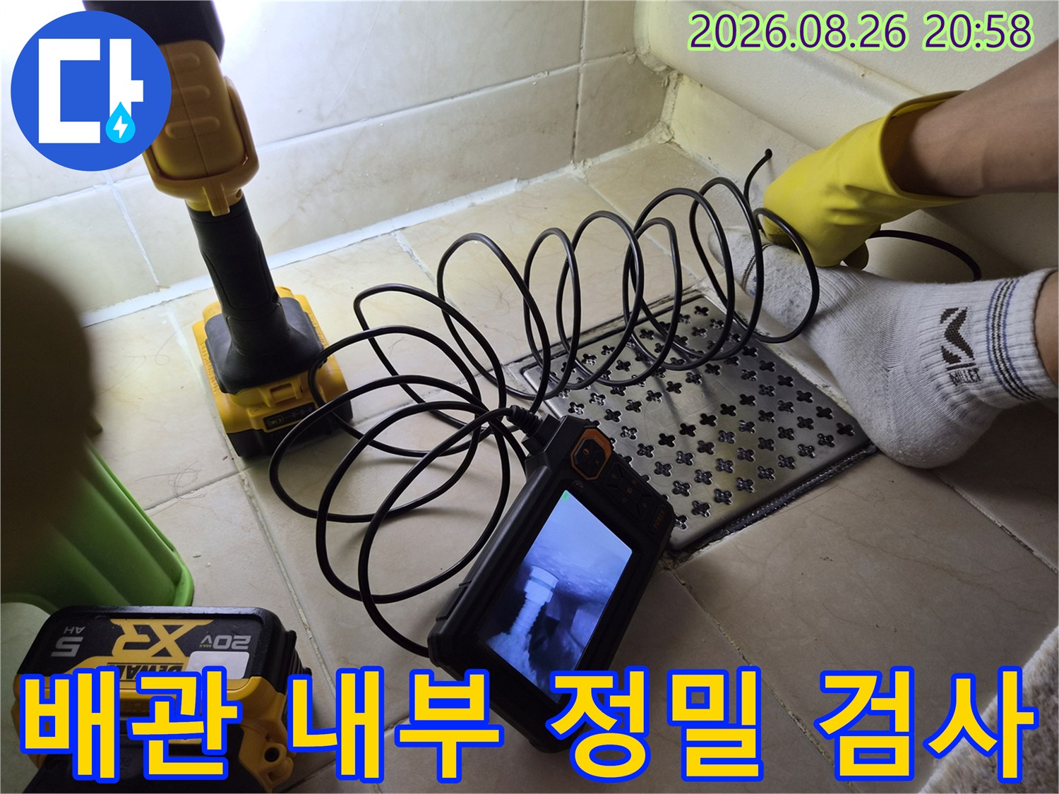 바닥 타일 위에서 배관 내시경 장비로 누수 지점을 찾는 과정