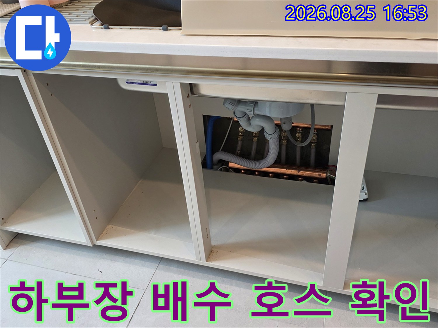 싱크대 하단부에 위치한 배수 호스와 배관 연결 상태를 보여줍니다.