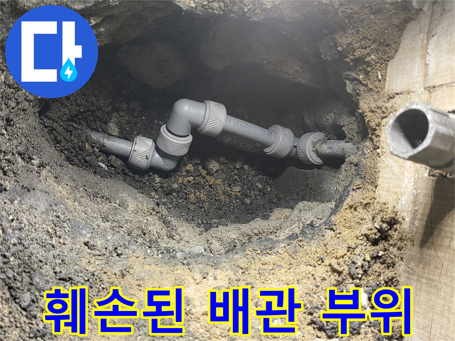흙과 모래 속에 드러난 파손된 PVC 배관 연결부