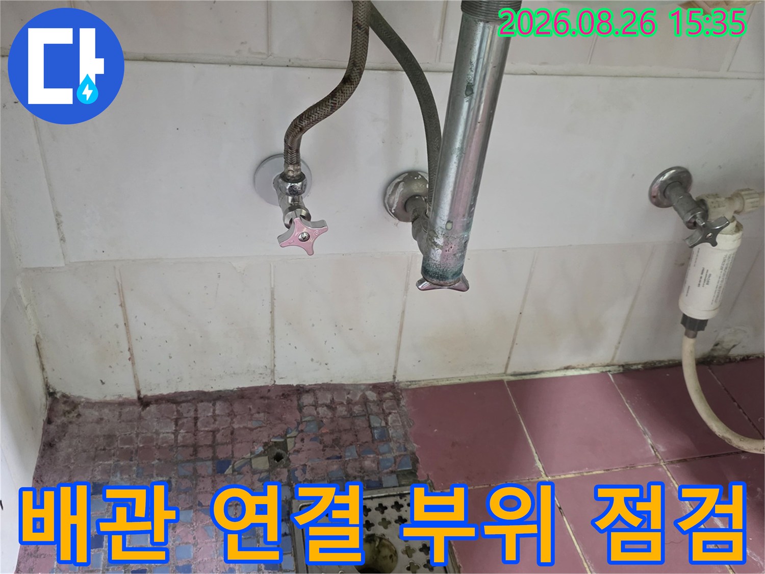 화장실 수전 밸브와 하수구 배관의 상태를 근접 촬영한 이미지입니다.