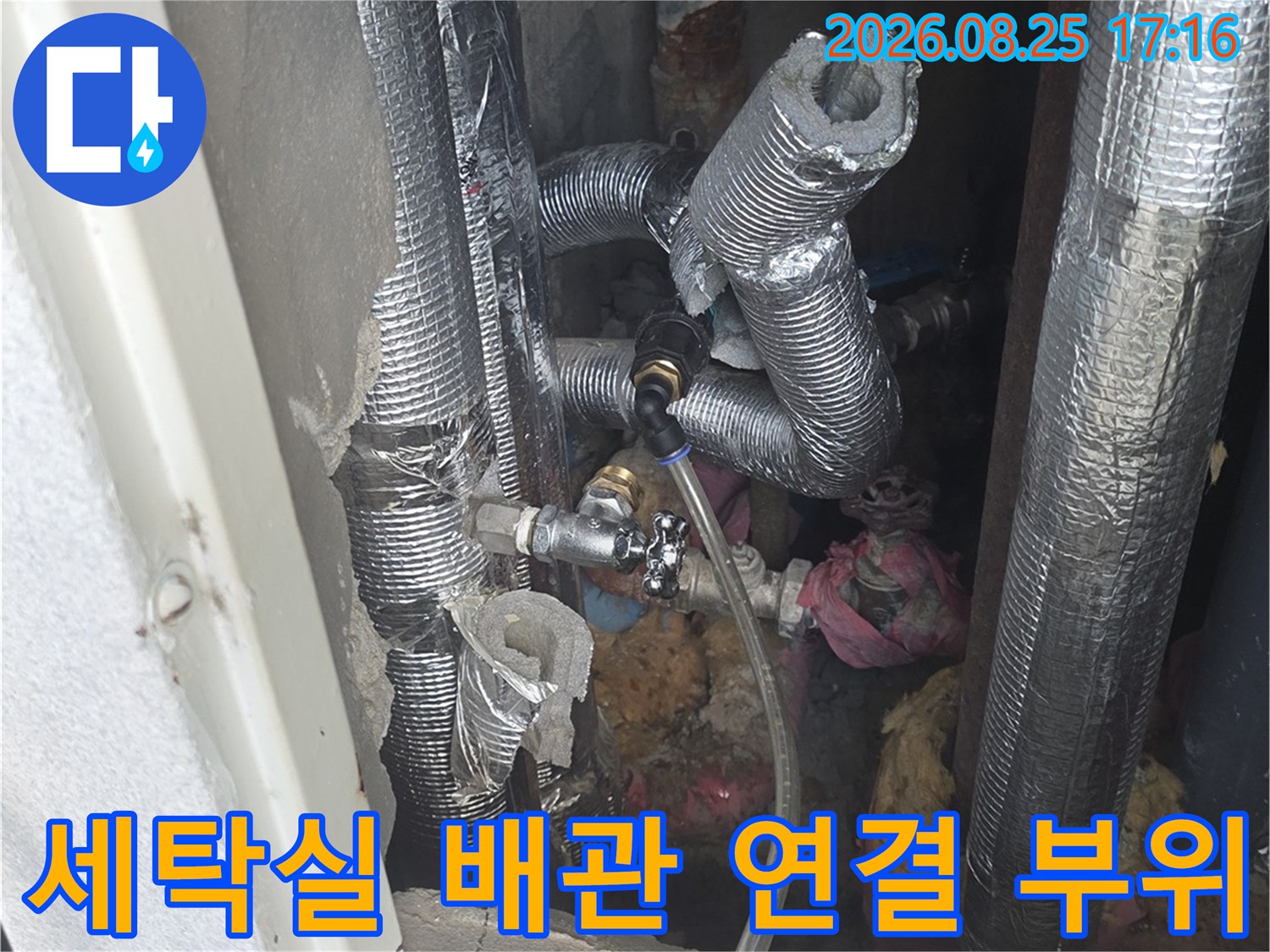 보온재로 감싸진 배관과 금속 연결 부품들의 모습입니다.