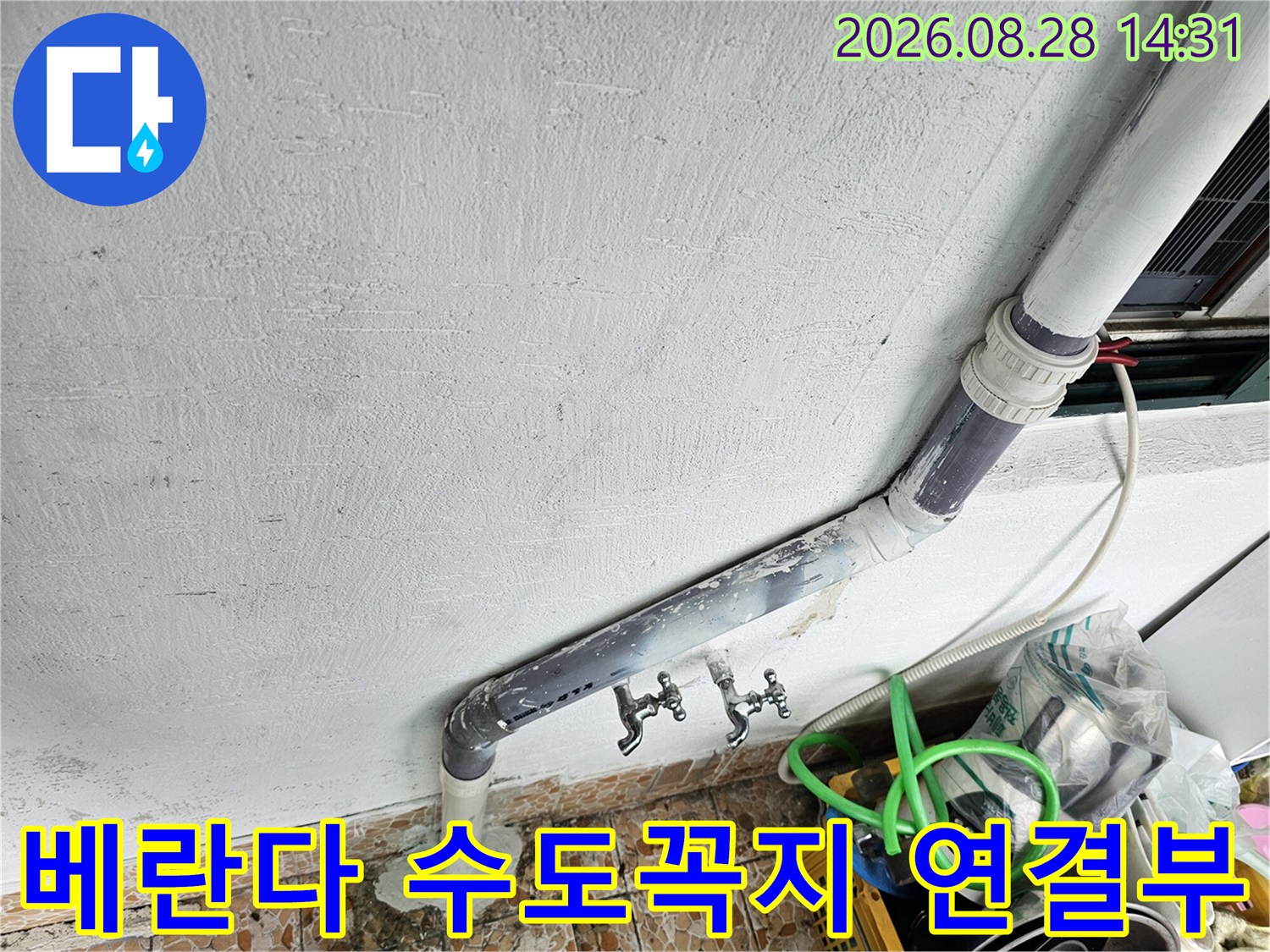 벽면에 고정된 수직 배수관과 수도꼭지 시설물 상세 촬영