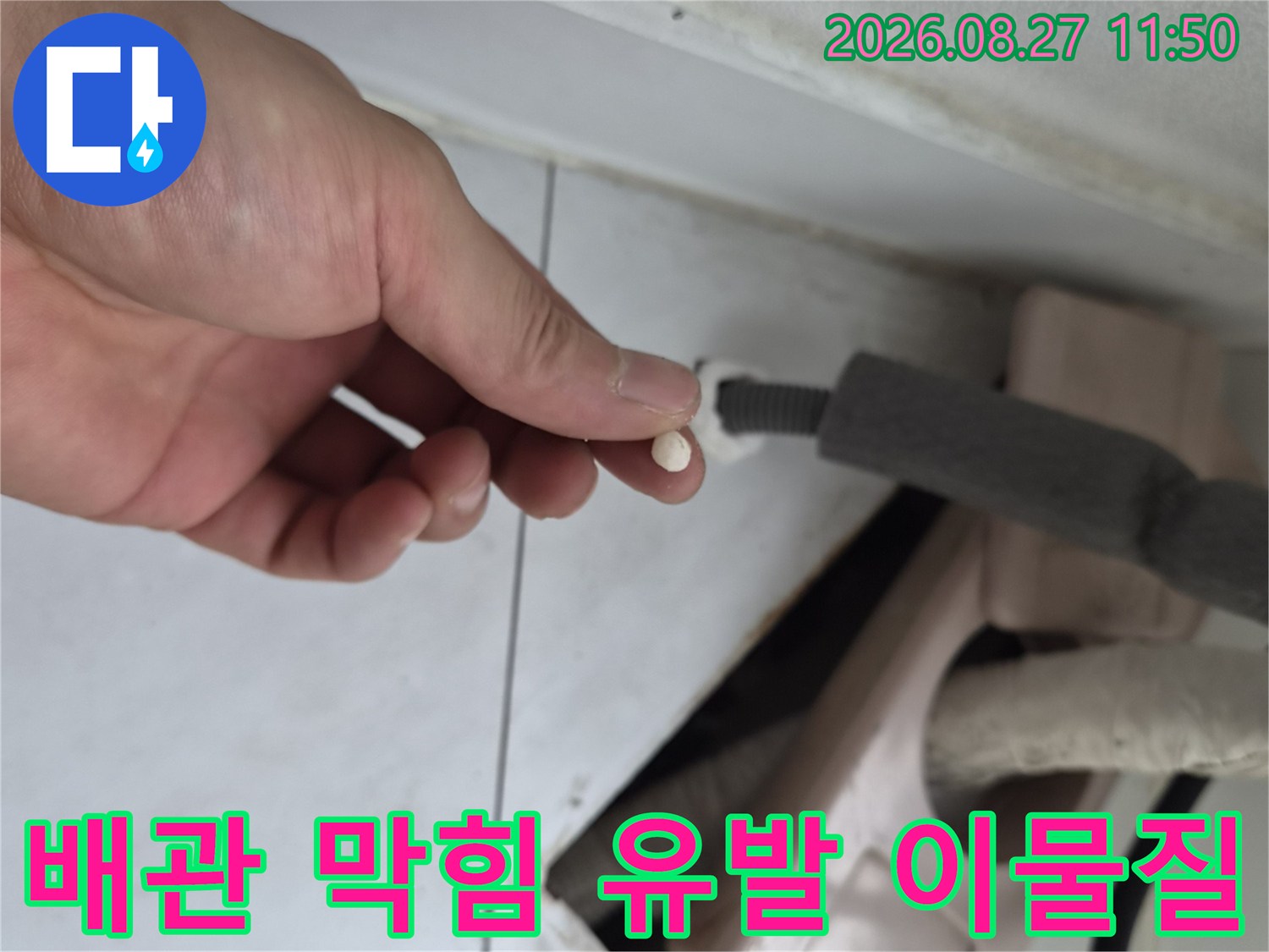 손가락 위에 올려진 배관 내부의 하얀색 오염 물질