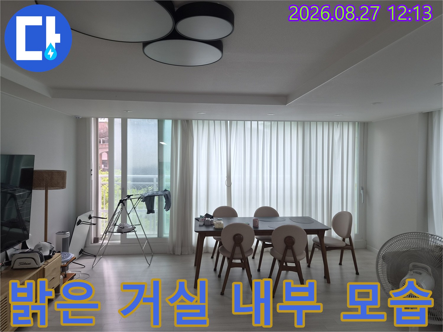 식탁과 의자가 배치된 밝고 깨끗한 거실의 풍경입니다.