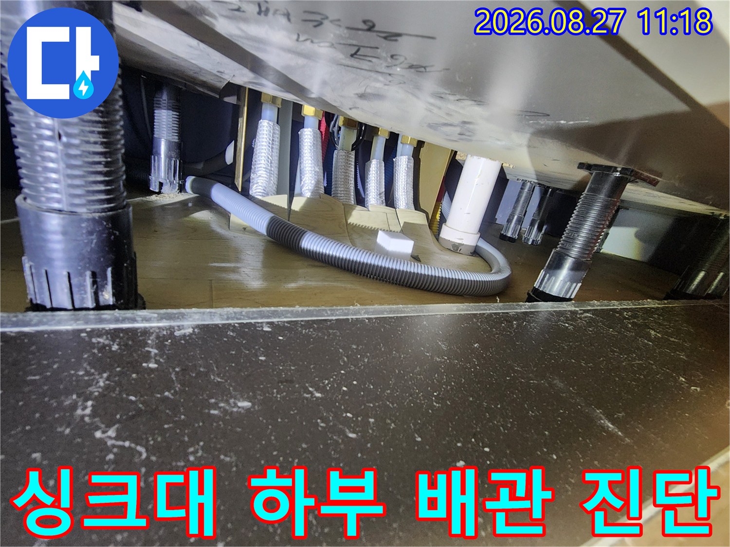 싱크대 밑 공간의 배관들을 따라가며 누수 지점을 정밀하게 찾는 모습입니다.