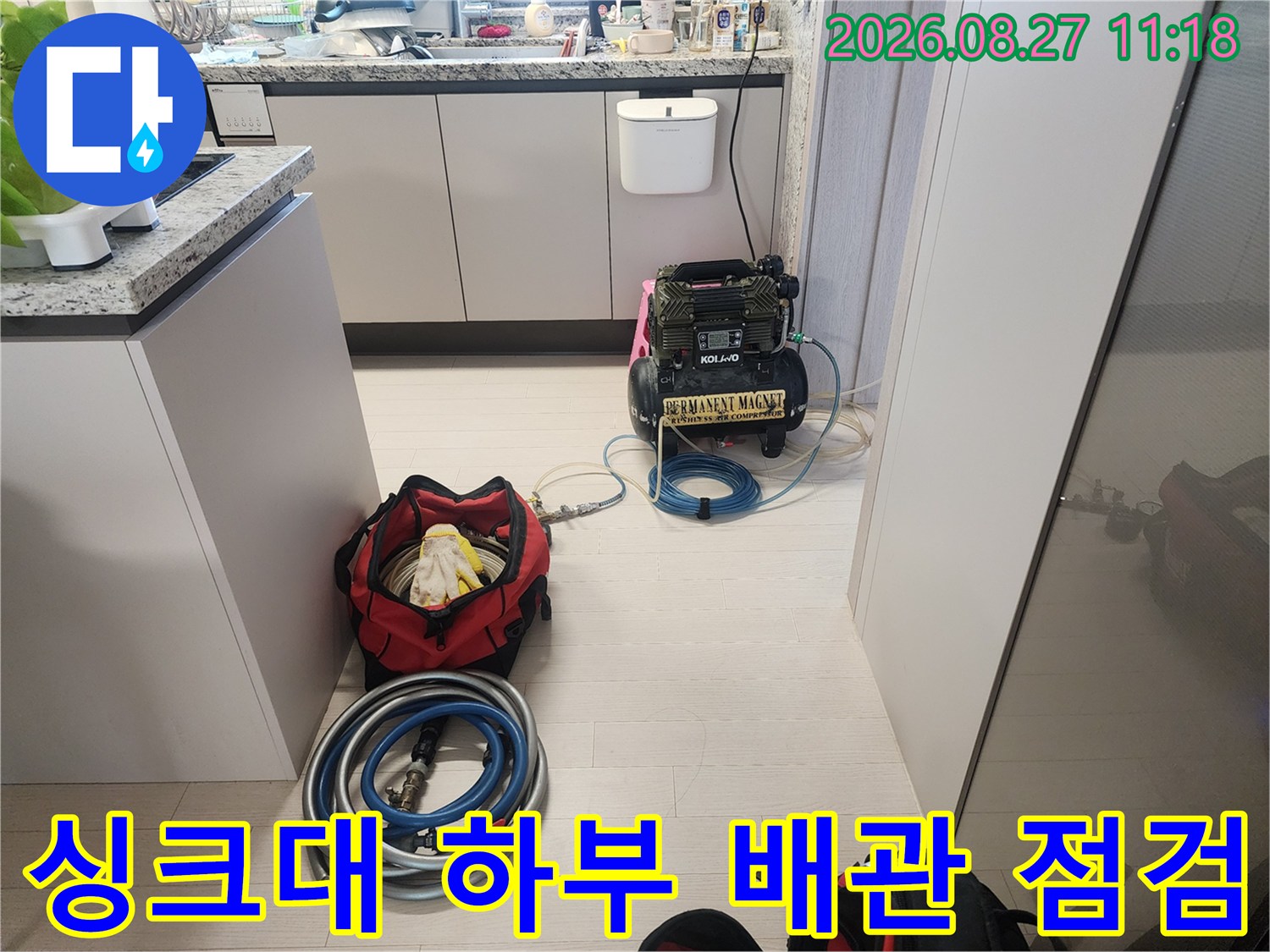 주방 싱크대 아래 공간에 배치된 누수 탐지용 장비와 호스