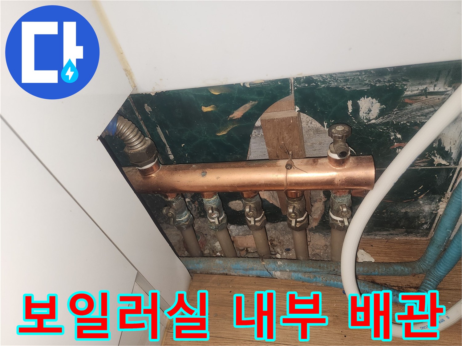 습기가 찬 벽면 근처의 구리 분배기 및 연결 호스