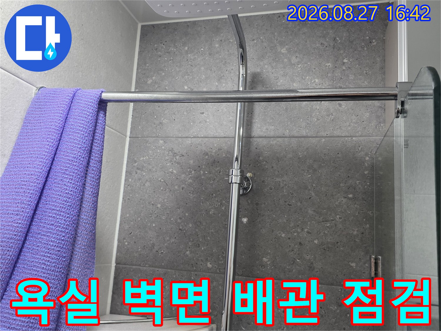 그레이톤 타일 벽면에 설치된 샤워기 수전과 연결 부위 상세 사진