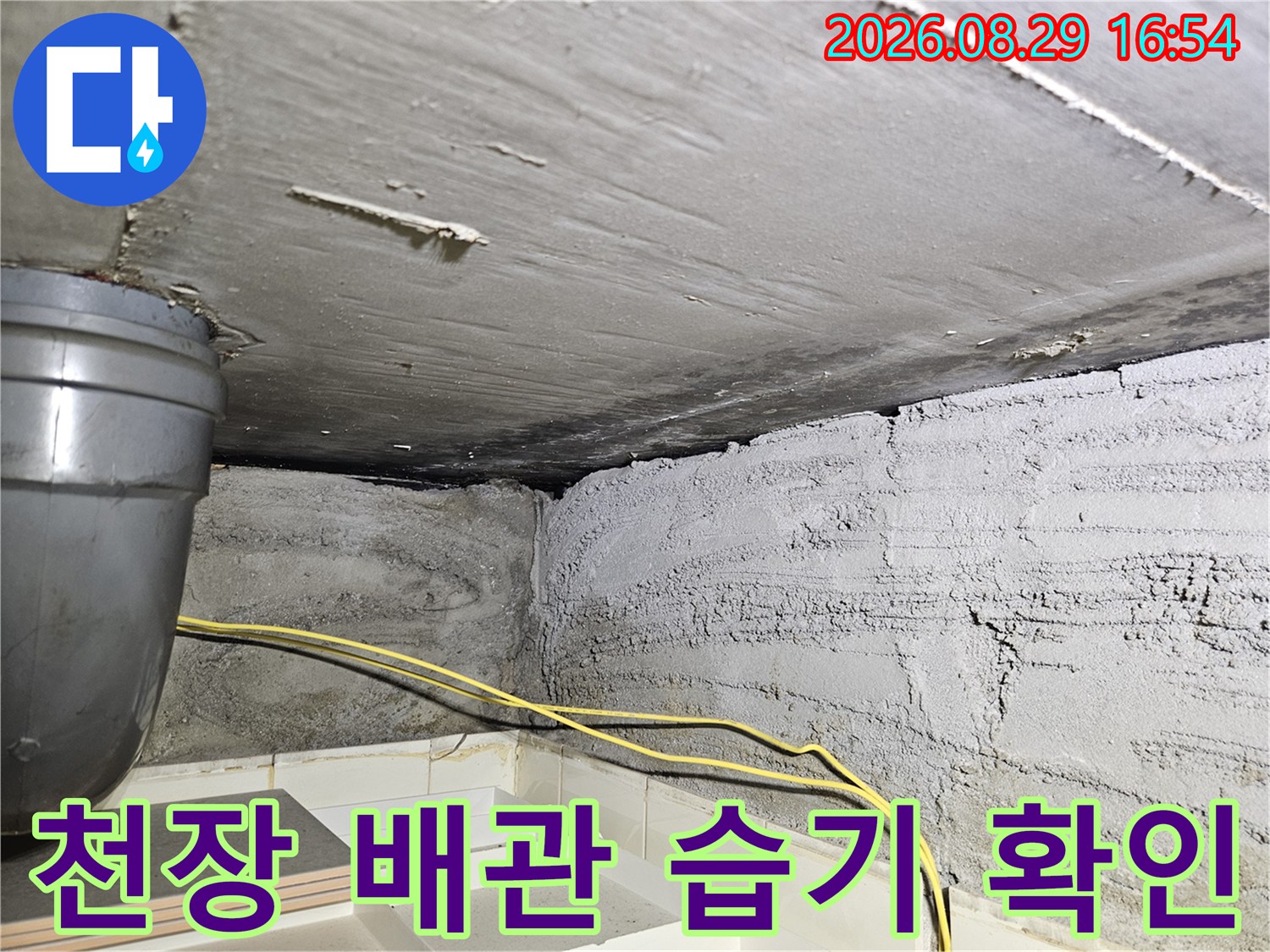 콘크리트 천장과-금속 배관 사이의 습기 찬 부분을 촬영했습니다.