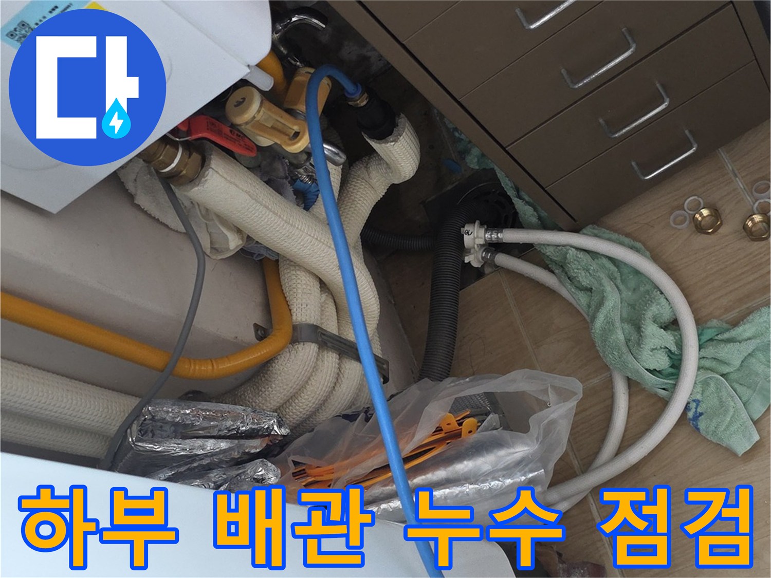 의정부 민락동 싱크대 하부장 내부의 젖은 배관 및 공구 배치 모습