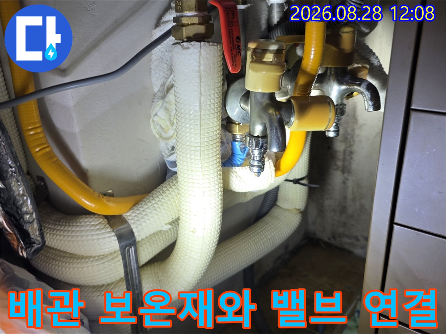 흰색 보온재로 감싸진 배관과 노란색 호스 및 금속 수전 장치 사진