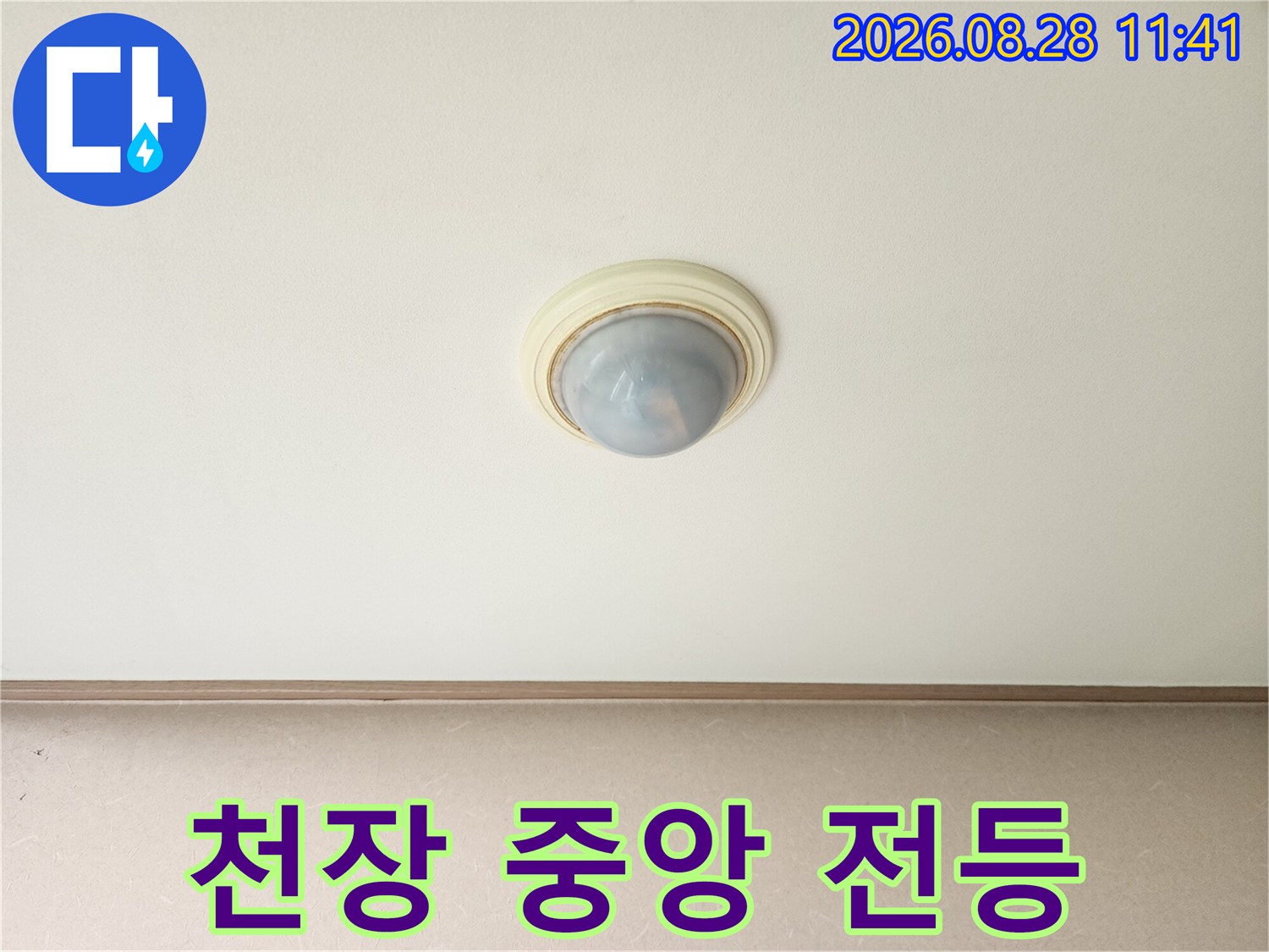 거실 천장 가운데 위치한 조명 기구입니다.