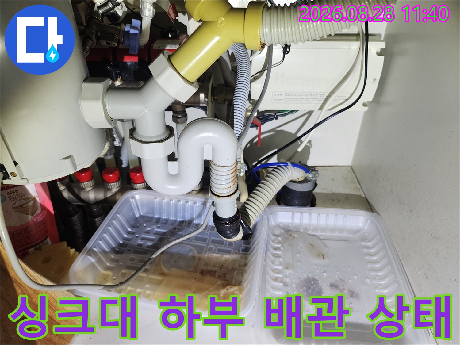 싱크대 하부장 내부의 배관 연결 부위와 물이 고인 트레이 상황