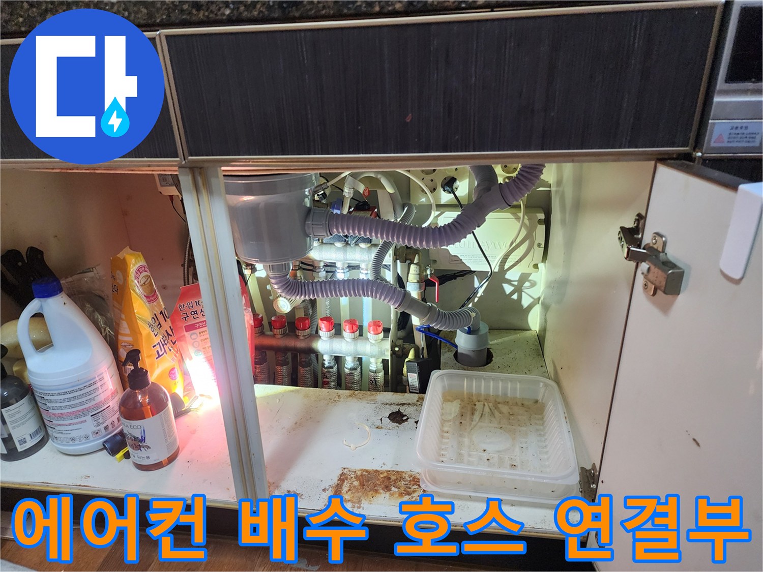 에어컨 드레인-호스와 주방 배수 파이프가 연결된 하부장 내부