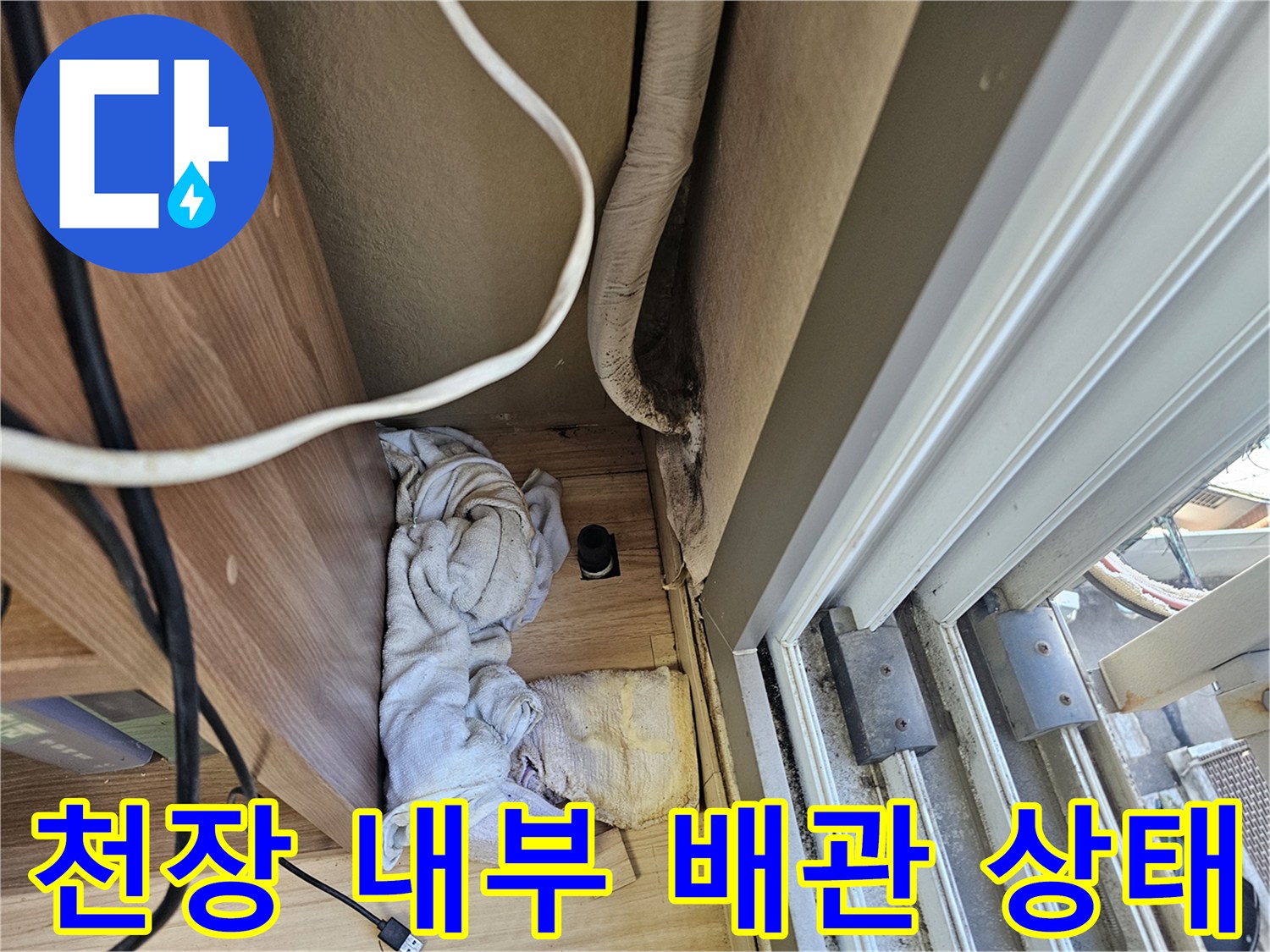 아파트 거실 천장 내부의 에어컨 배관과 보온재 상태를 보여주는 사진입니다.