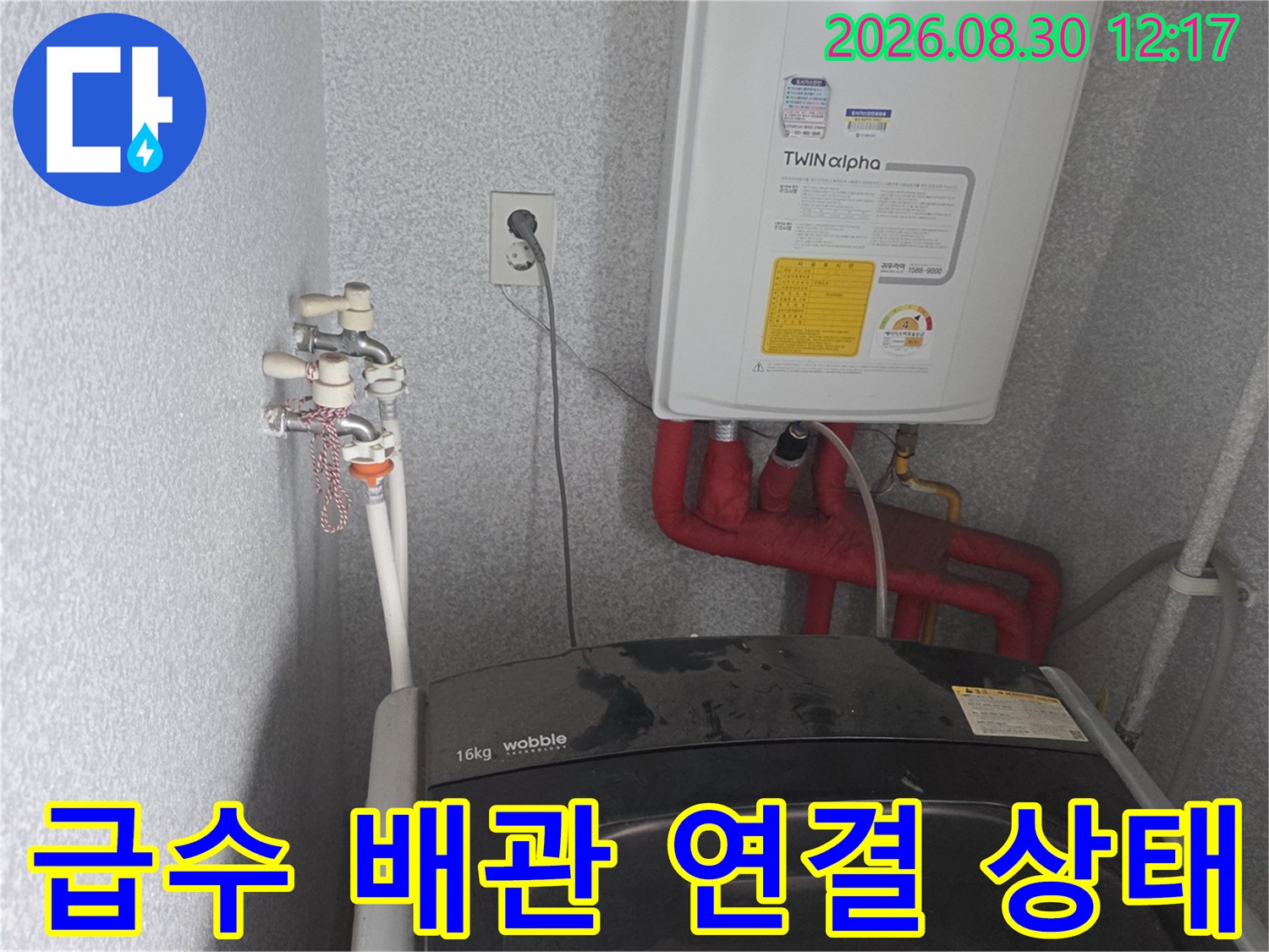 세탁실 온수기 하단의 급수 밸브와 배관 모습입니다.