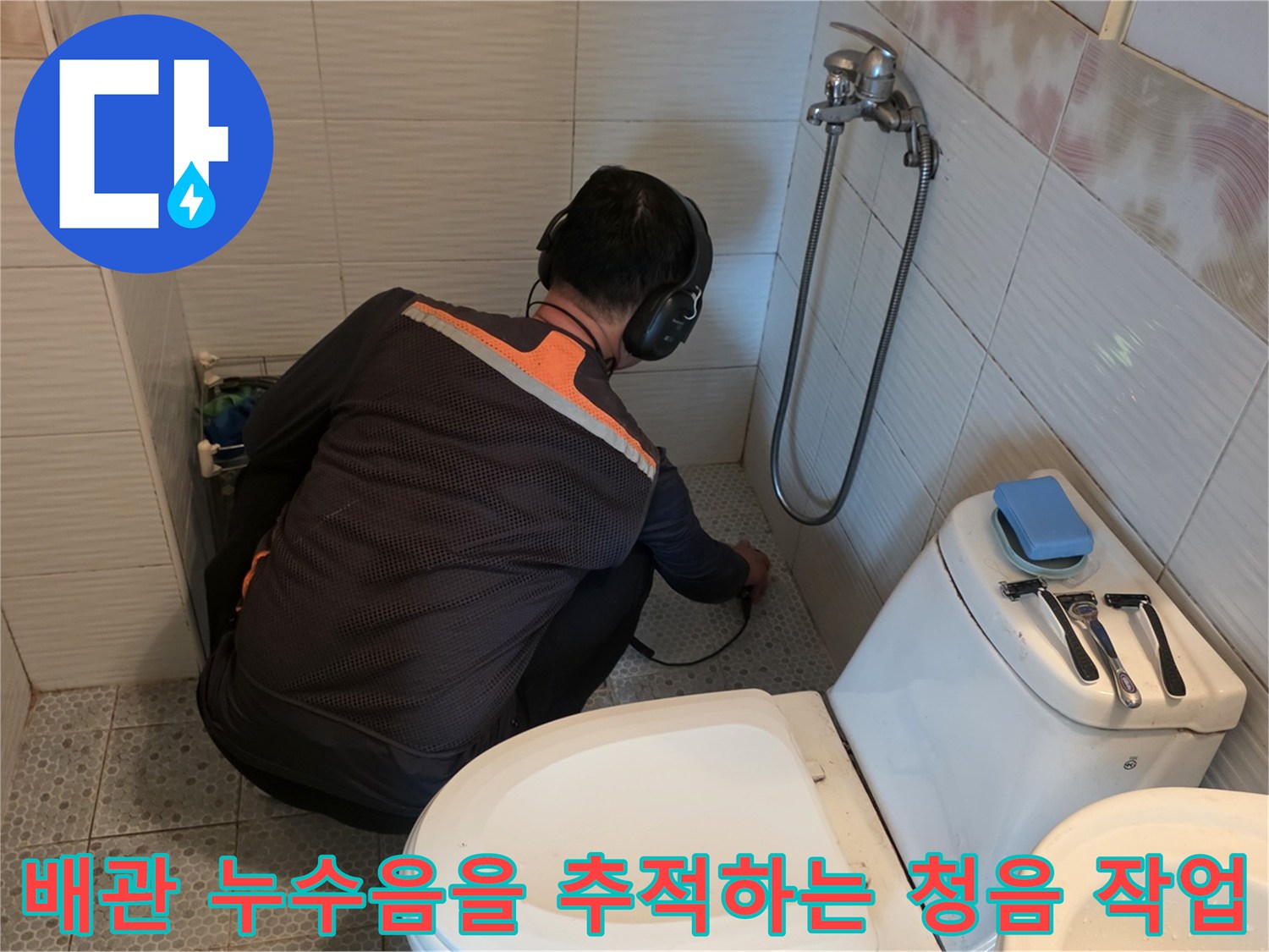 엔지니어가 헤드셋을 쓰고 변기 및 세면대 주변 배관의 이상 소음을 탐색하고 있습니다.