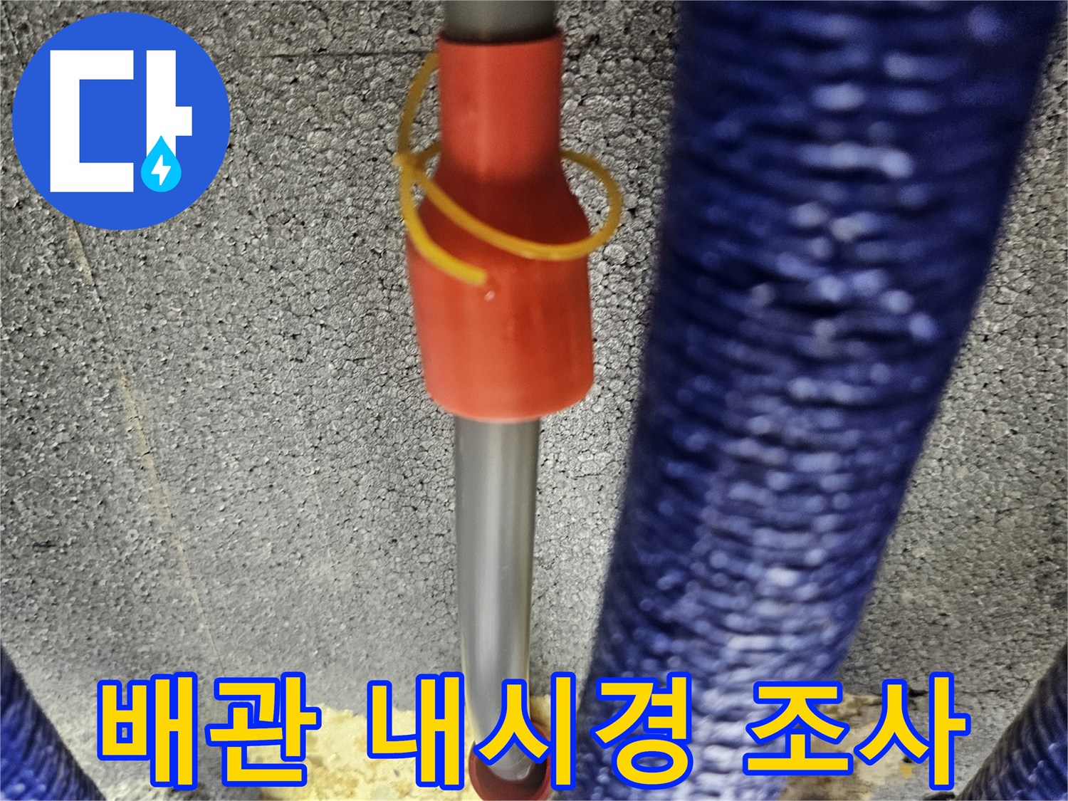 타공된 벽면 내부의 파란색 배관과 내시경 카메라