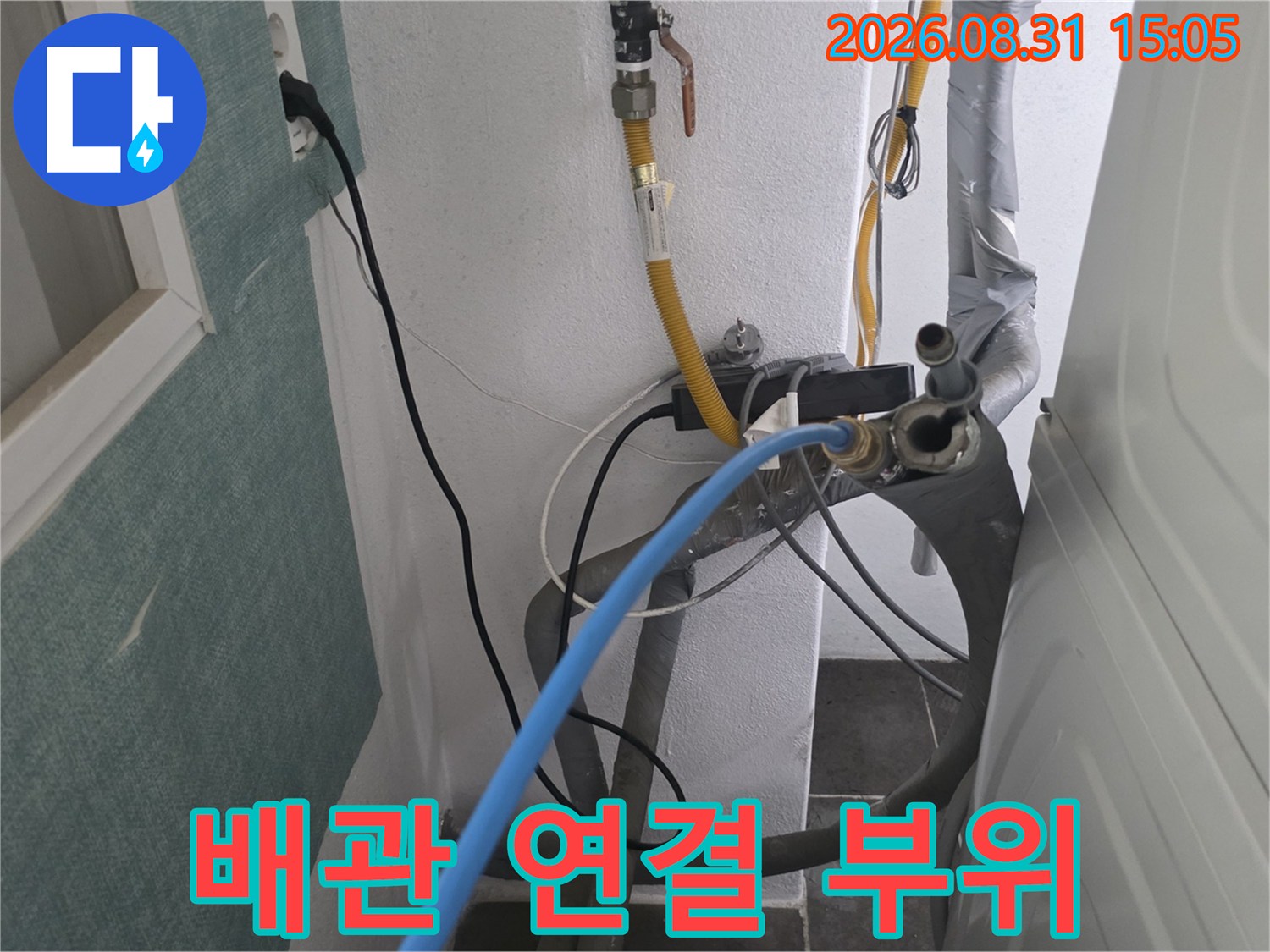 벽면에 설치된 밸브와 파란색 호스가 연결된 배관 점검 장면