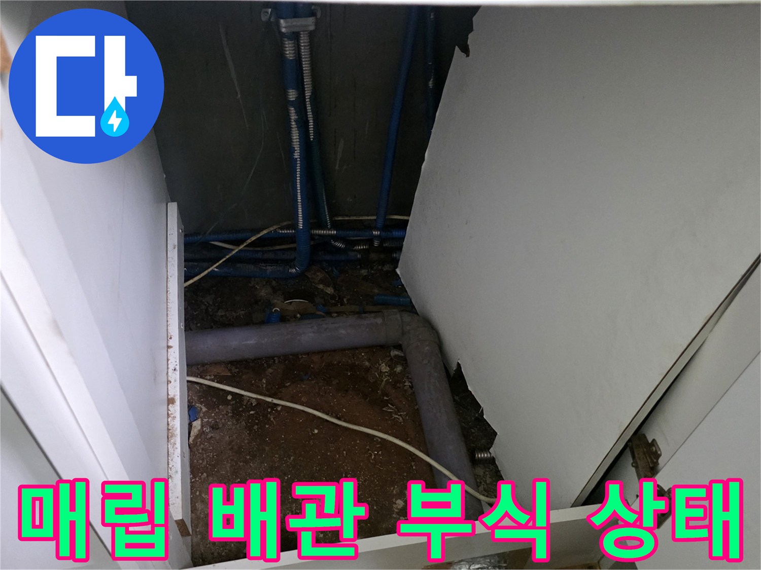 싱크대 아래 젖은 흙과 노후된 금속 분배기 모습