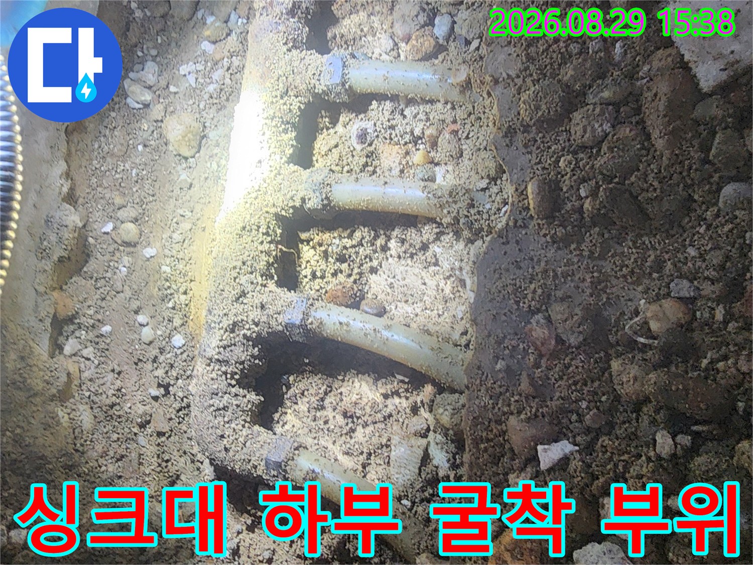 자갈층 아래 노출된 싱크대 배관 및 분배기 라인