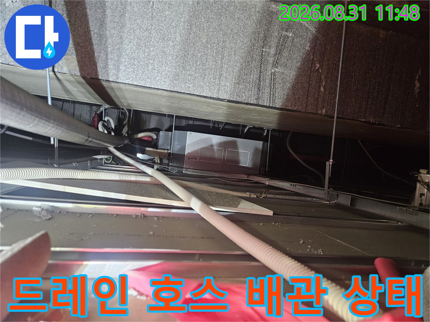 천장 내부 드레인 호스와 연결된 배관 구조를 근접 촬영한 사진입니다.