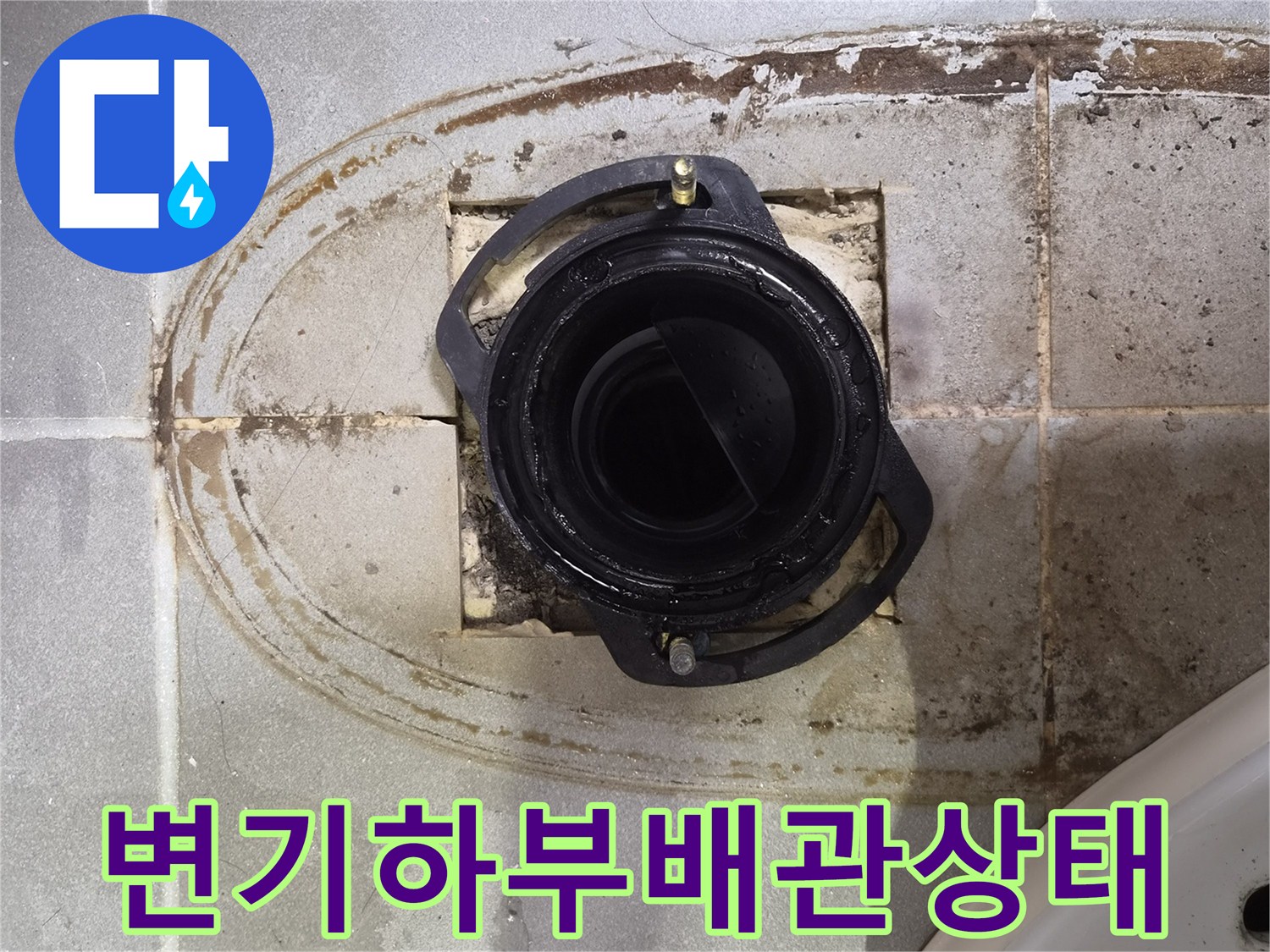 변기 제거 후 드러난 배수구 주변의 젖은 타일