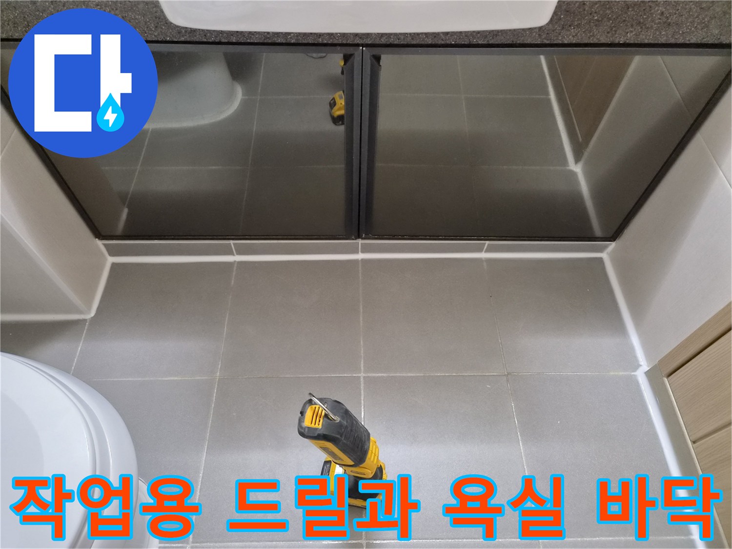 회색 타일 위에 놓인 노란색 전동 공구