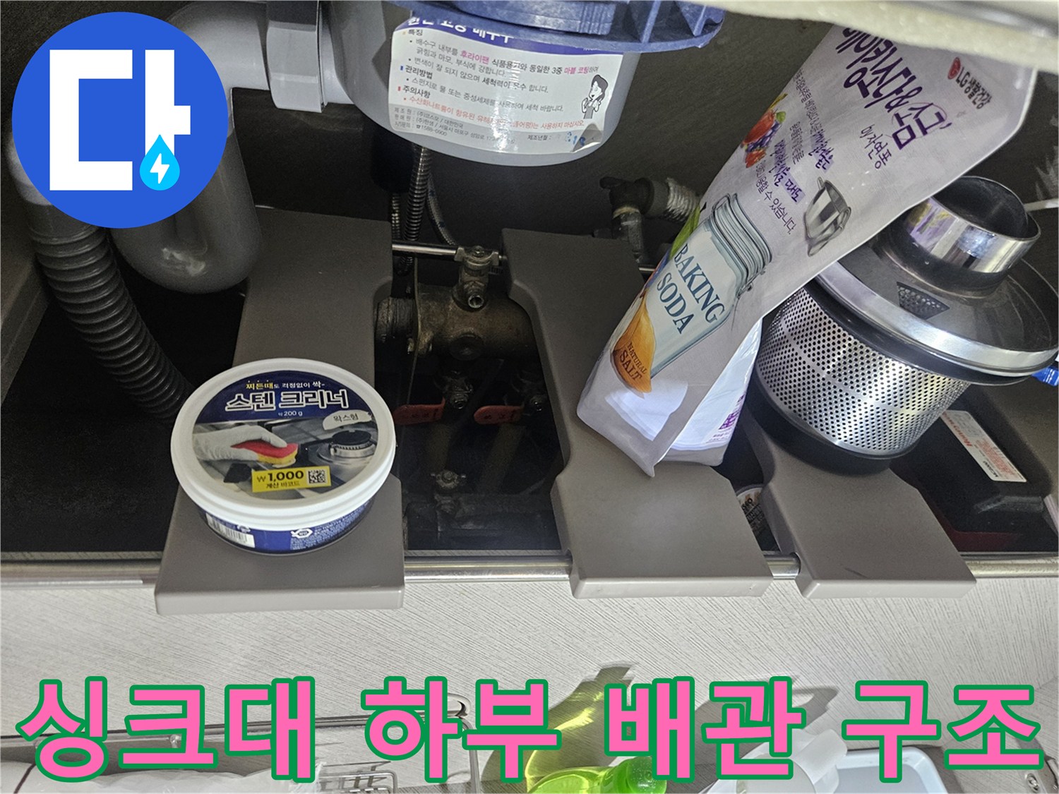 싱크대 아래쪽의 배수 호스와 연결된 금속 부품들의 모습