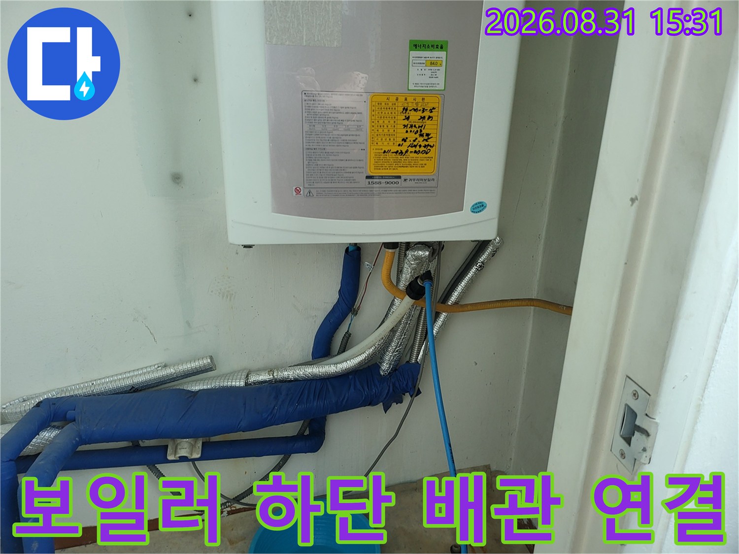 보온재로 감싸진 파란색 배관과 가스 관이 있는 보일러실 모습입니다.