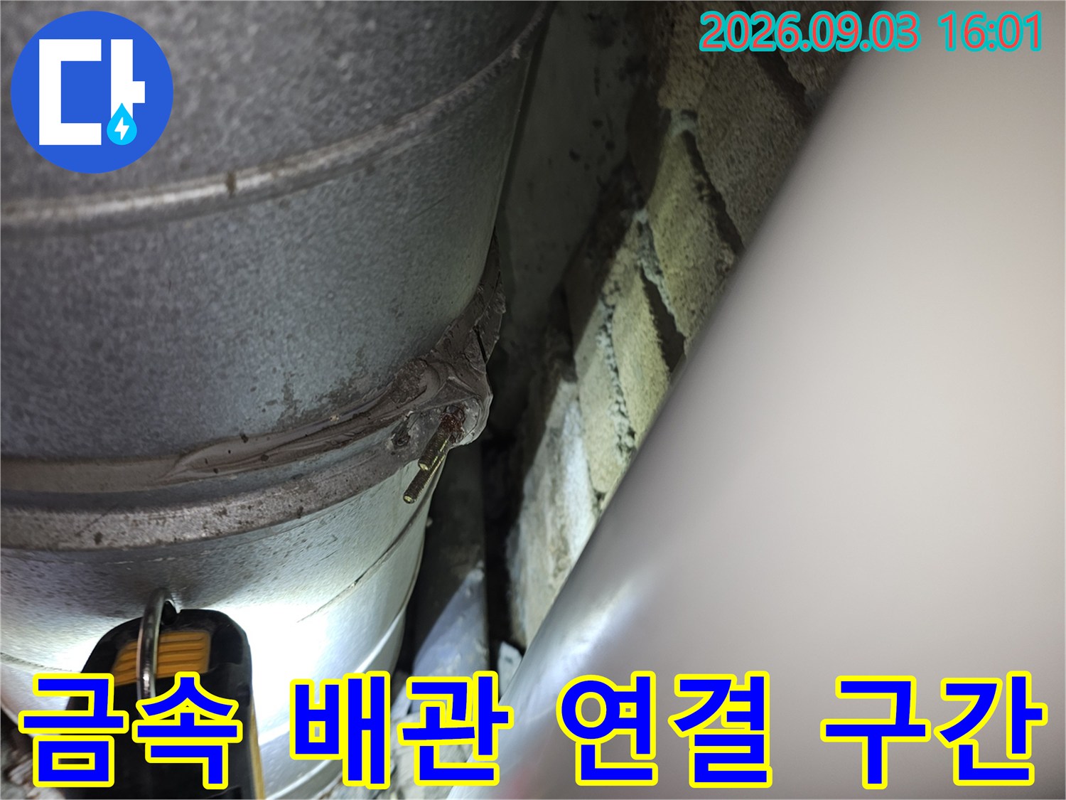 배관의 굴곡진 연결 부위와 벽돌 마감면을 촬영한 사진