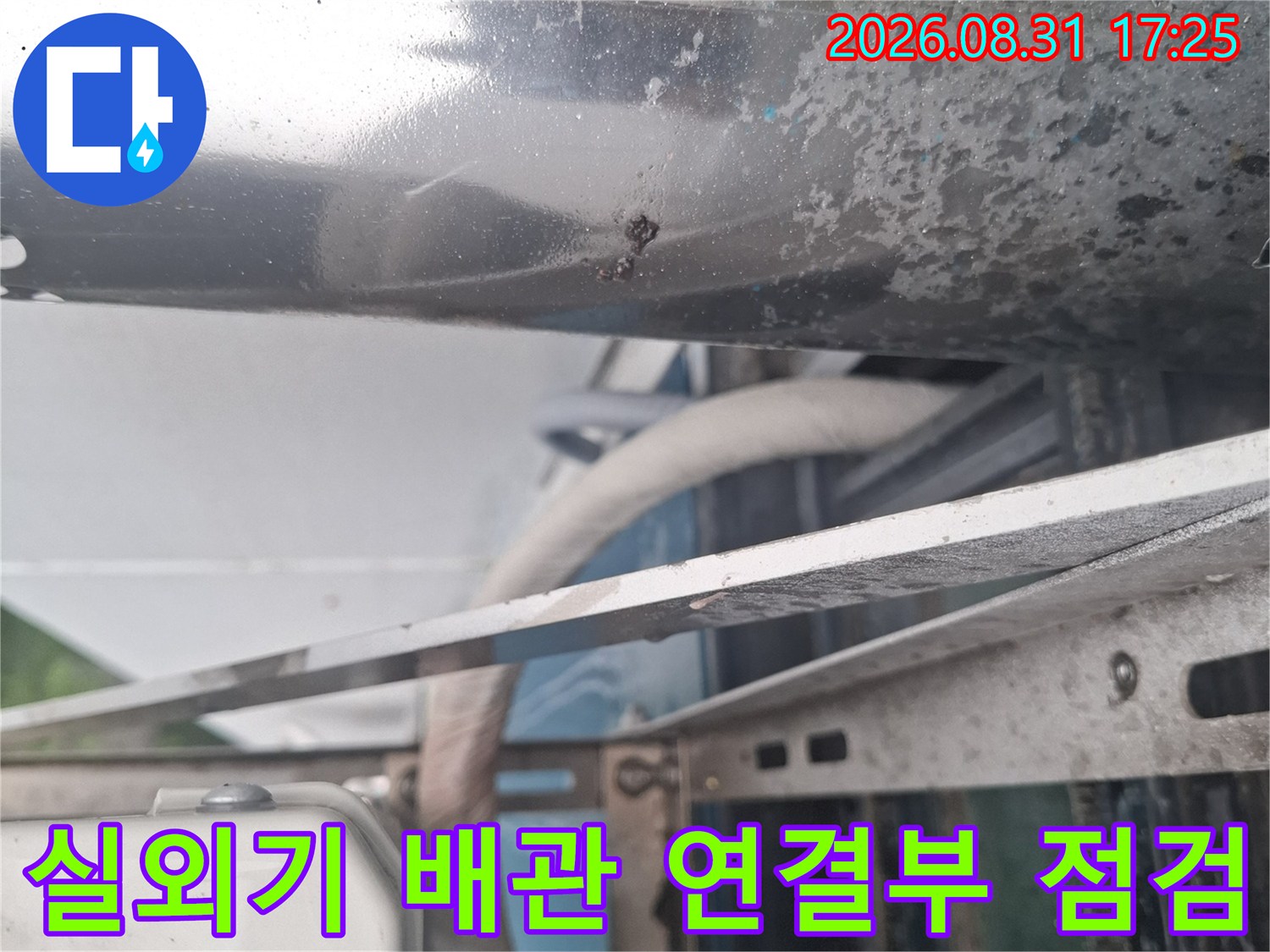 에어컨 금속 배관과 주변 거치대의 노후 상태를 보여줍니다.
