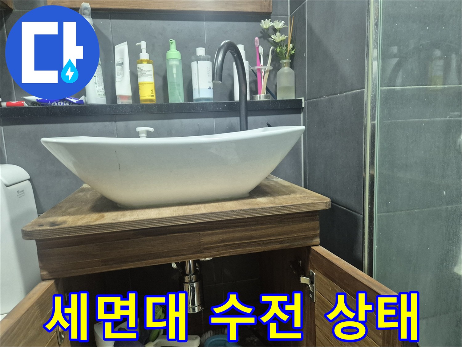 화장실 세면대 위로 설치된 검은색 수전과 흰색 세면대 모습