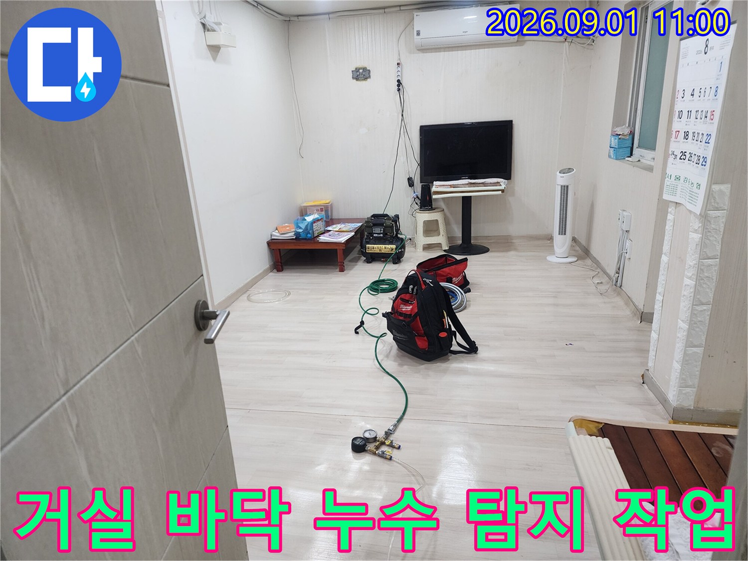 거실 공간에 펼쳐진 배관 검사 장비와 도구들