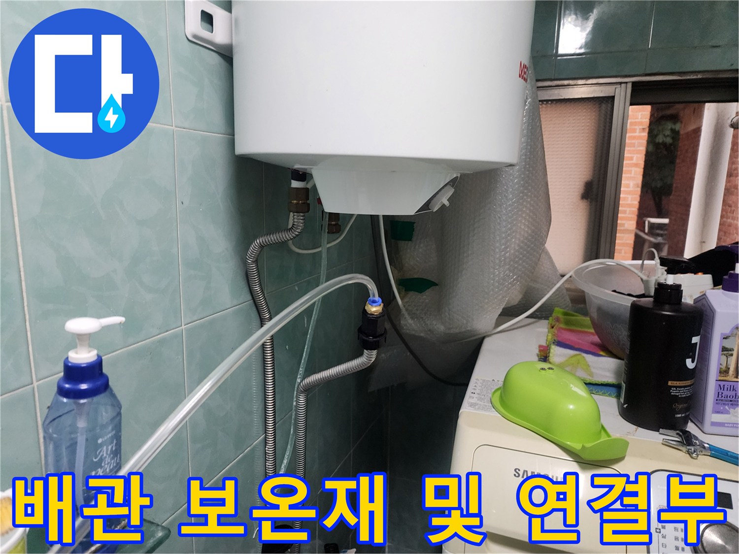 은색 배관과 온수기 하단 연결 부위 근접 촬영