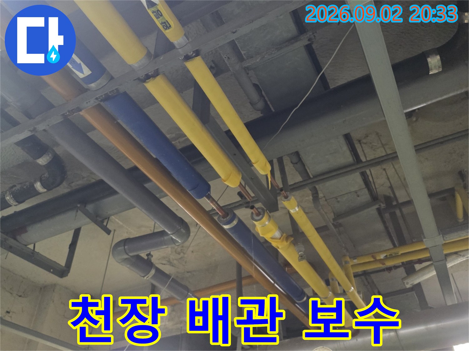 천장 배관 부위 - 노란색 및 파란색 보온재가 설치된 배관 라인