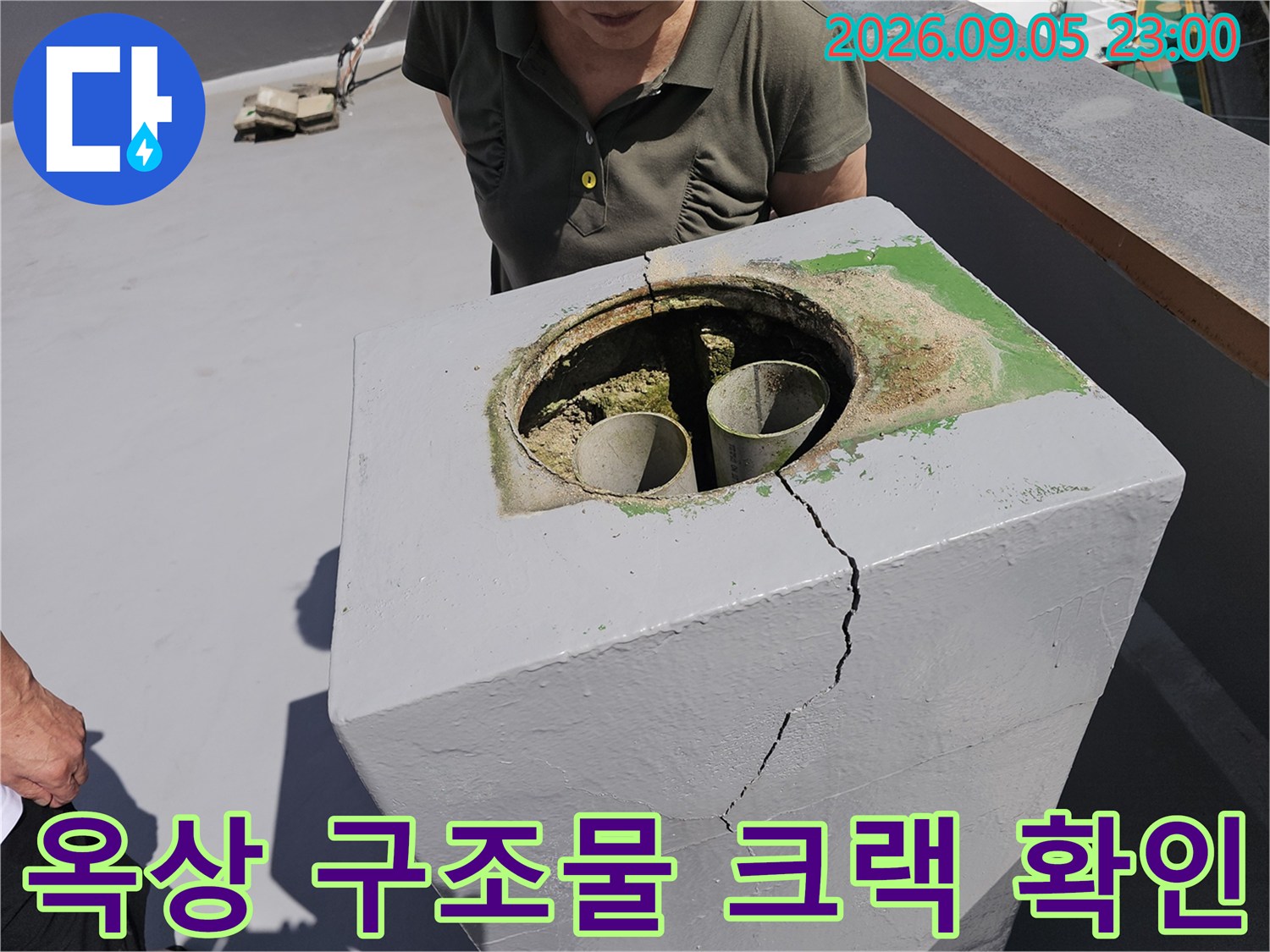 배관 입구 주변의 갈라진 콘크리트와 균열이 진행된 구조물 모습