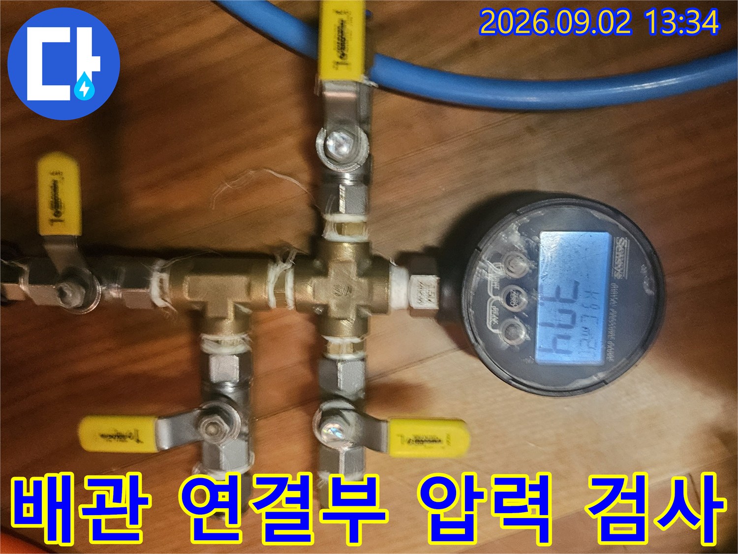 노란색 손잡이 밸브와 파란색 호스가 연결된 배관 점검 장비