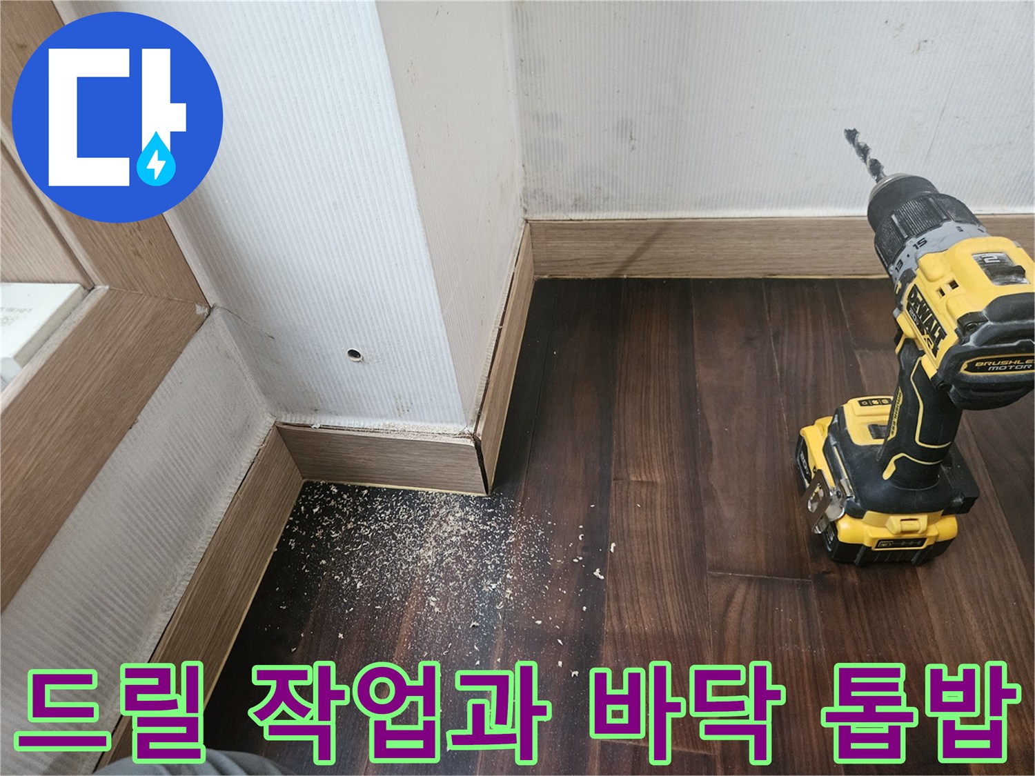 전동 드릴로 마루를 뚫는 공사 중인 모습 - 배관 수리 과정