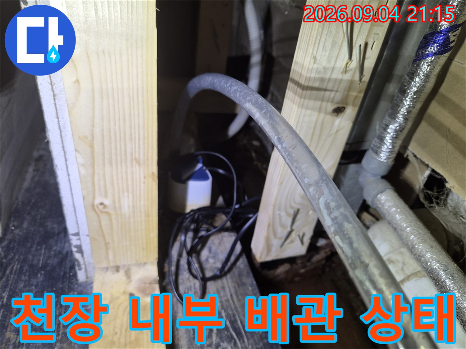 상가 천장 구조물-에어컨 드레인 호스와 주변 목재 프레임