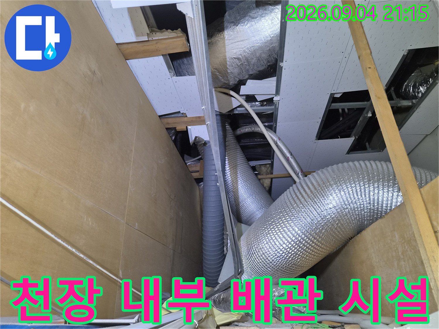 상가 천장 점검구 내부에 설치된 은박 보온 덕트와 에어컨 배수관 모습입니다.