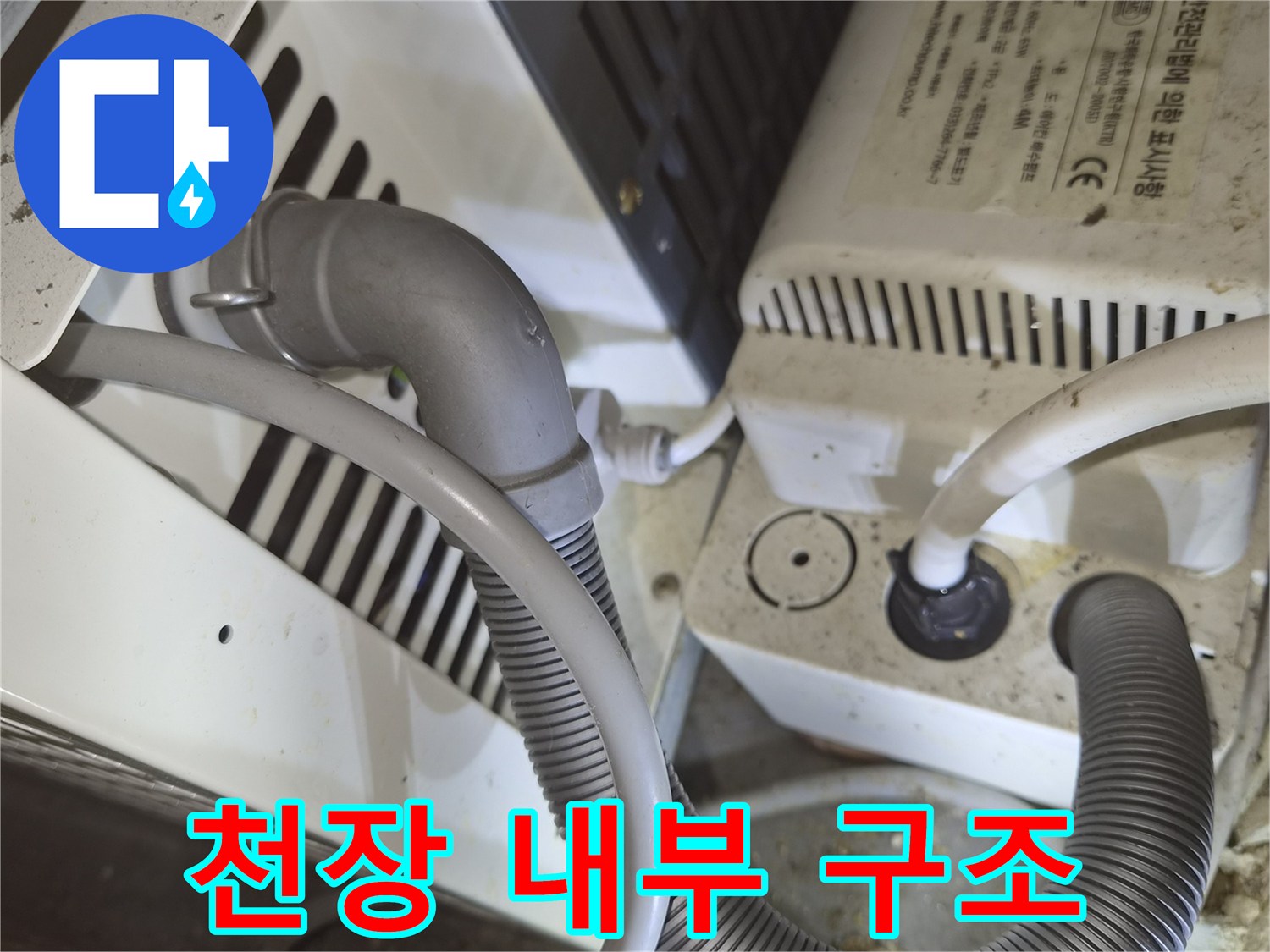 하얀색 장비와 회색 주름관이 연결된 천장 점검구 내부 모습입니다.