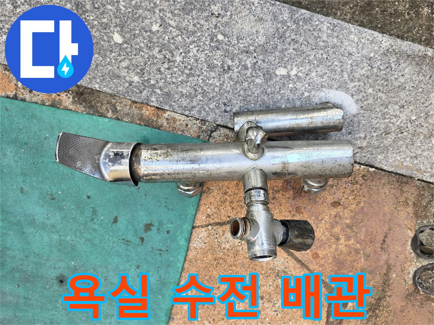 화장실 벽면에 설치된-금속 재질의 수전 부품